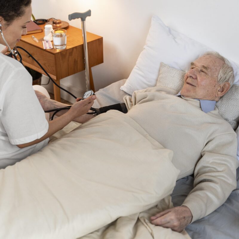 Healthcare worker checking blood pressure of an elderly patient, highlighting post-acute care support challenges